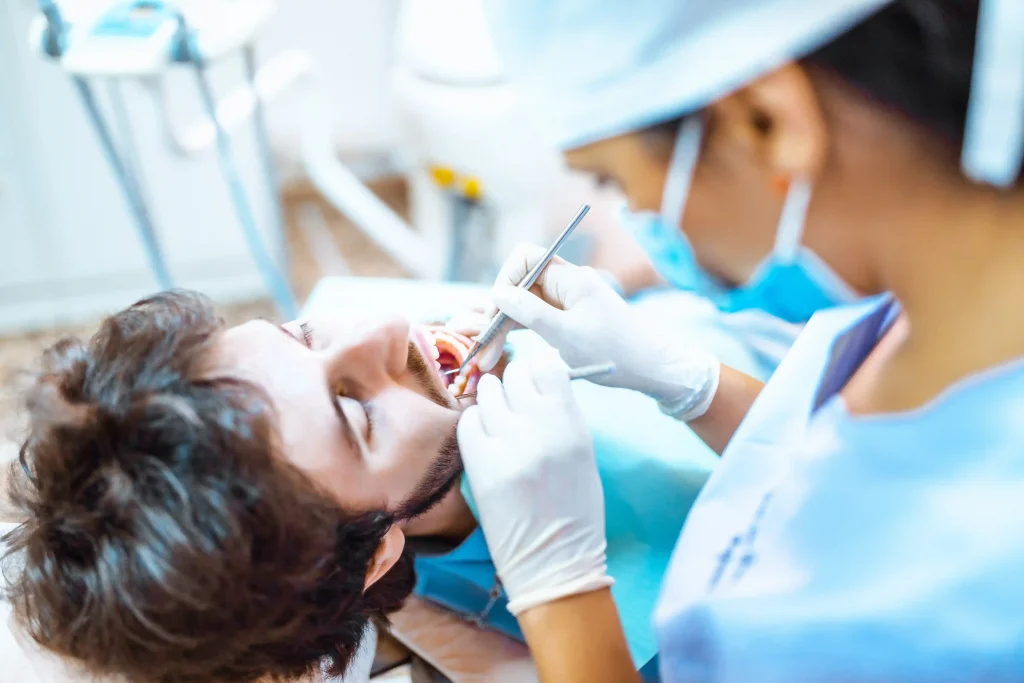 image of a dental hygienist cleaning the teeth of a patient for his oral hygiene at Liberty Dentists dental clinic located at Shoreditch, London